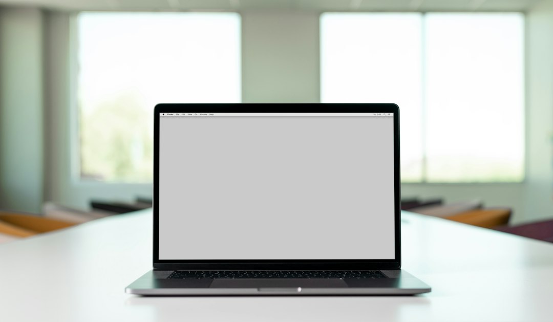 Professional using a laptop in a bright modern workspace.